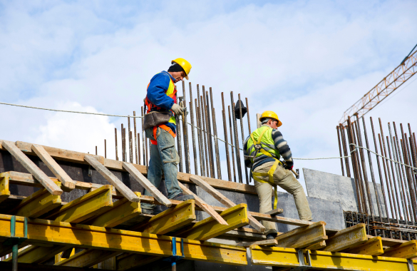 constructores caminando sobre vigas trabajando en una obra