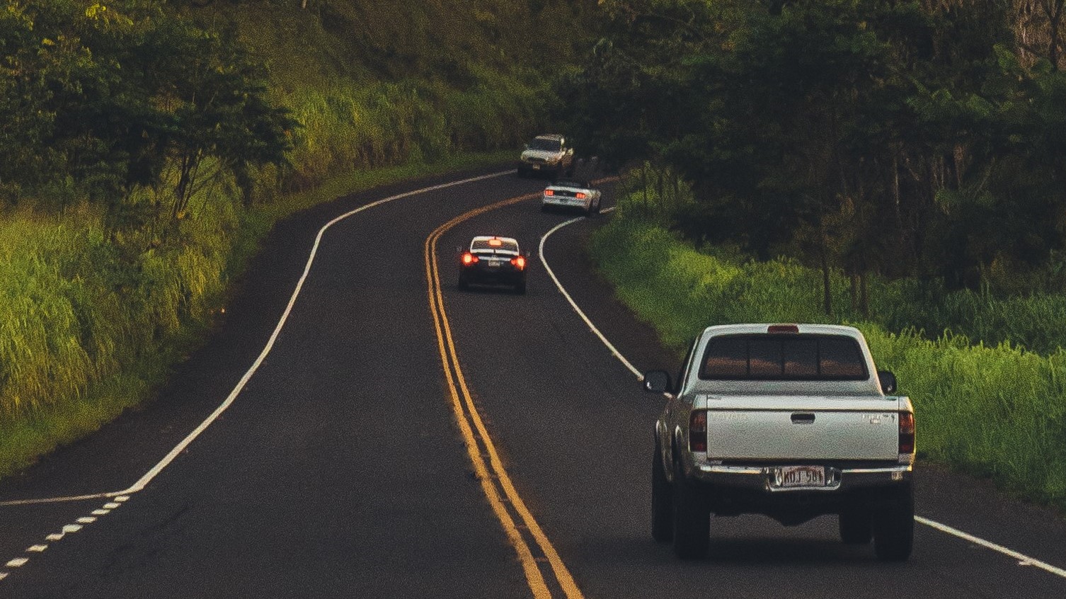 Un carro recorriendo una carretera entre montañas