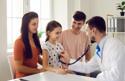 Botón Chequeo Pediátrico Doctor aplicándole un chequeo médico a una niña frente a sus padres.