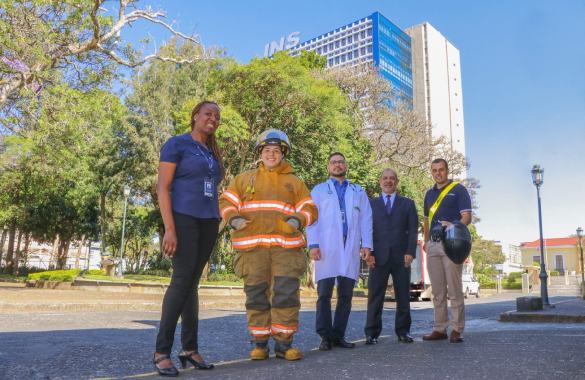 Personas vestidas de diferentes profesiones rente al edificio central del INS