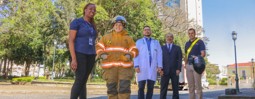 5 personas vestidas de diferentes profesiones afueras del instituto nacional de seguros sede central